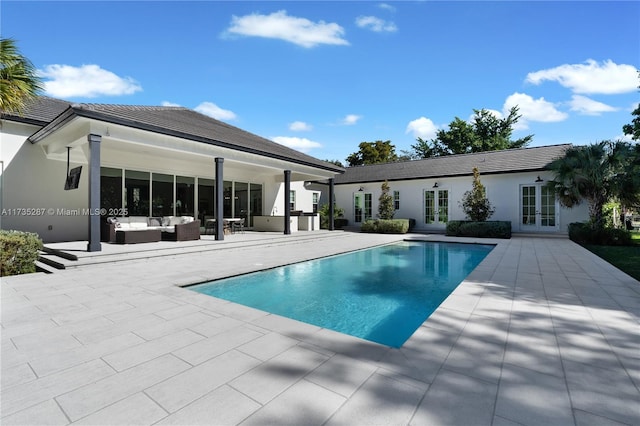 view of pool featuring outdoor lounge area, a patio area, and french doors