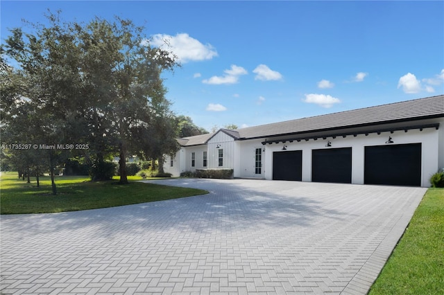 view of front of property with a garage and a front lawn