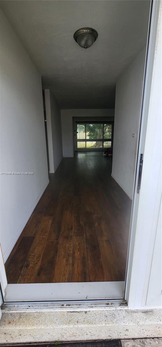 hallway with dark wood-type flooring