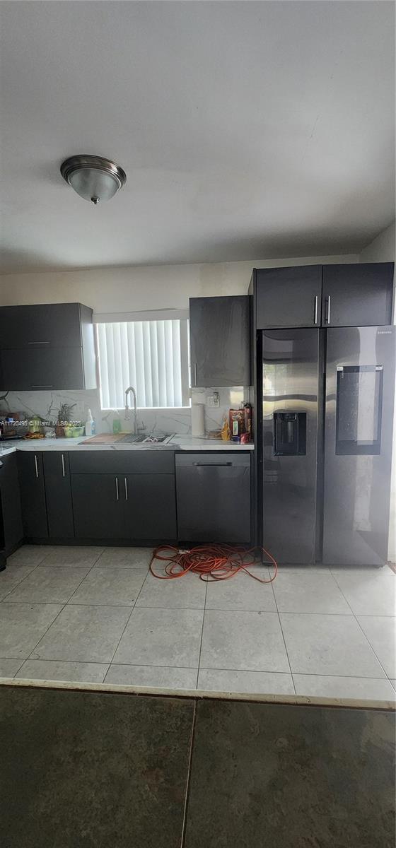 kitchen featuring appliances with stainless steel finishes, sink, and light tile patterned floors