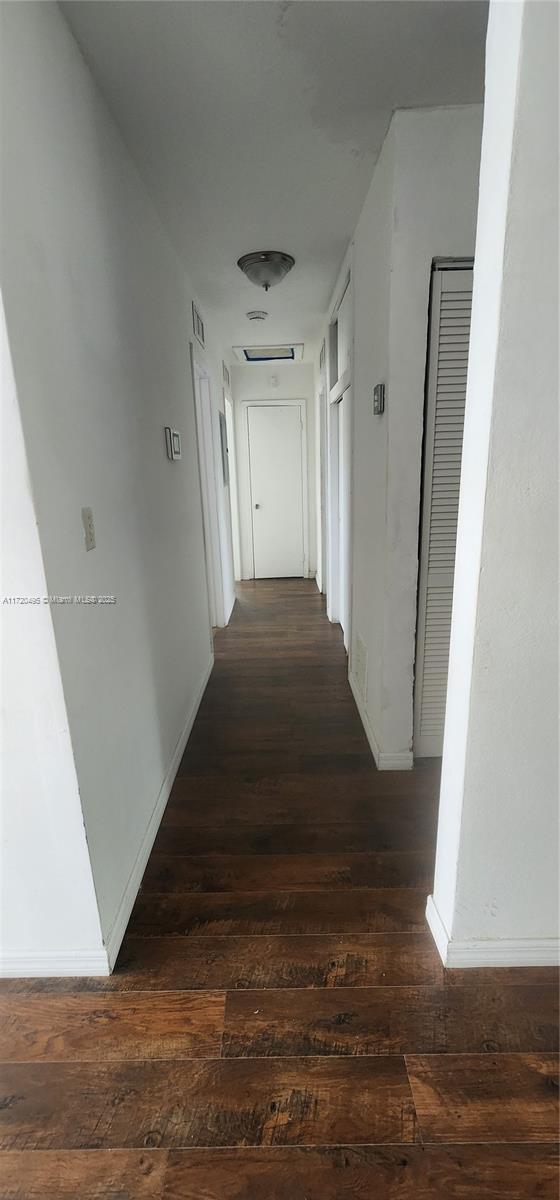 corridor with dark wood-type flooring