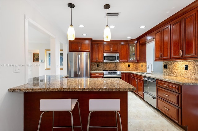 kitchen featuring light stone counters, decorative light fixtures, stainless steel appliances, and decorative backsplash