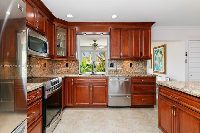 kitchen featuring light stone countertops, appliances with stainless steel finishes, sink, and backsplash