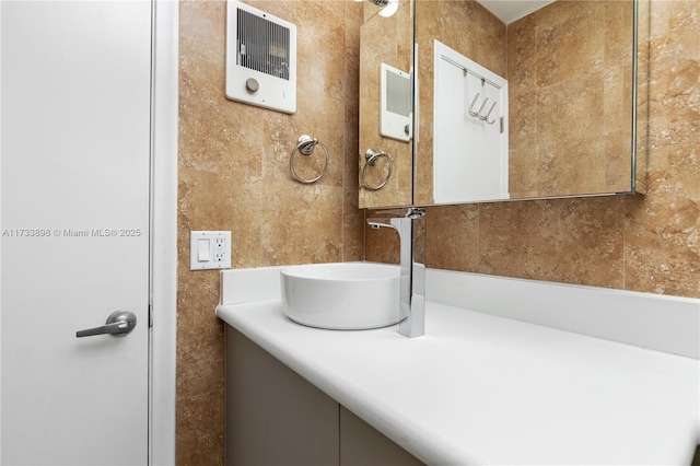 bathroom with vanity and tile walls