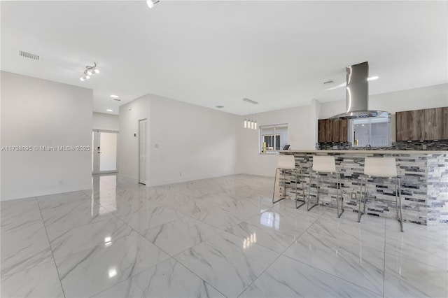 kitchen with a breakfast bar and island exhaust hood