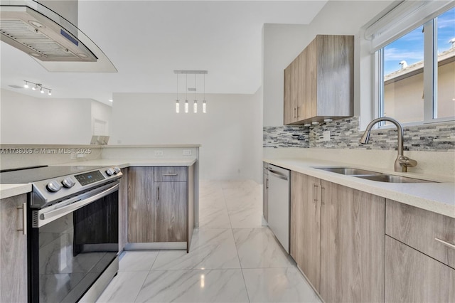 kitchen featuring sink, wall chimney range hood, stainless steel appliances, tasteful backsplash, and decorative light fixtures