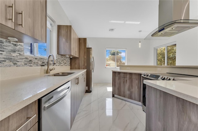 kitchen with appliances with stainless steel finishes, tasteful backsplash, sink, hanging light fixtures, and island exhaust hood