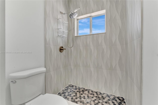 bathroom with toilet and a tile shower