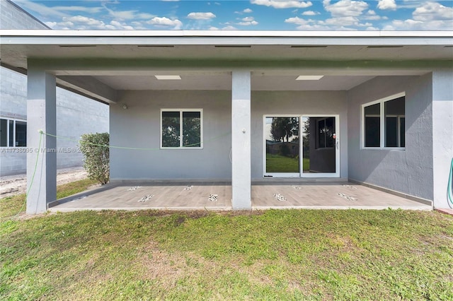 rear view of house with a patio and a yard