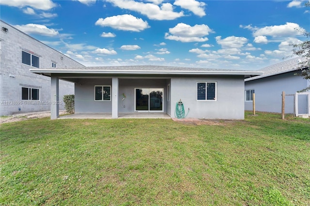 rear view of house with a patio and a yard