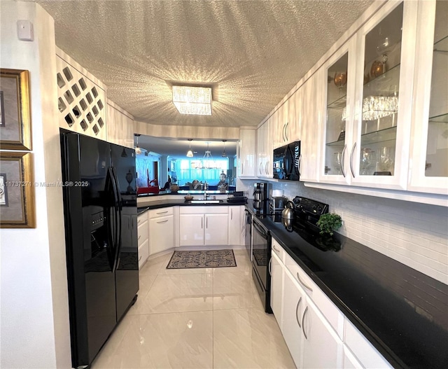 kitchen with white cabinetry, sink, decorative backsplash, black appliances, and a textured ceiling