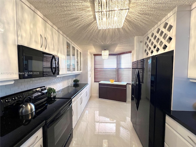 kitchen featuring black appliances, a chandelier, and white cabinets