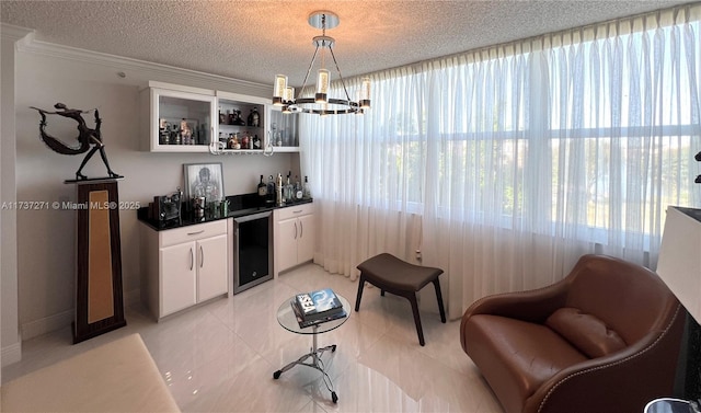 bar featuring pendant lighting, white cabinetry, wine cooler, a notable chandelier, and a textured ceiling