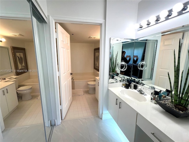 bathroom featuring vanity, toilet, tile patterned flooring, and a washtub