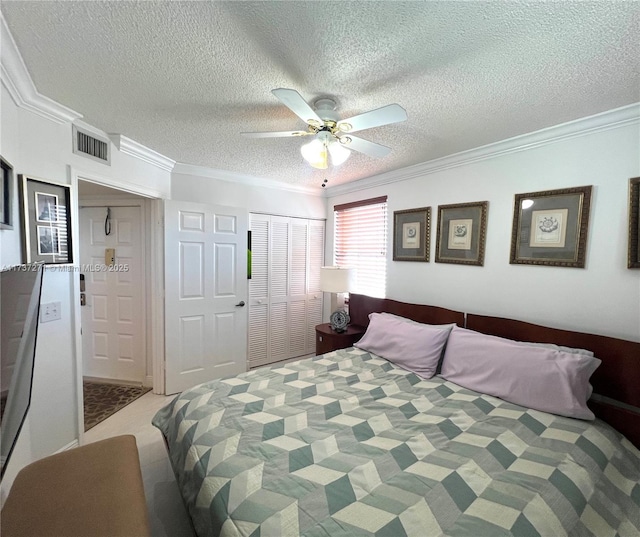 carpeted bedroom featuring ceiling fan, ornamental molding, a closet, and a textured ceiling