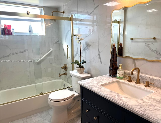 full bathroom with toilet, vanity, shower / bath combination with glass door, and tile walls