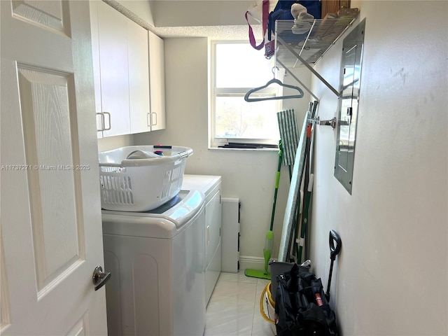 washroom featuring cabinets and washer and clothes dryer