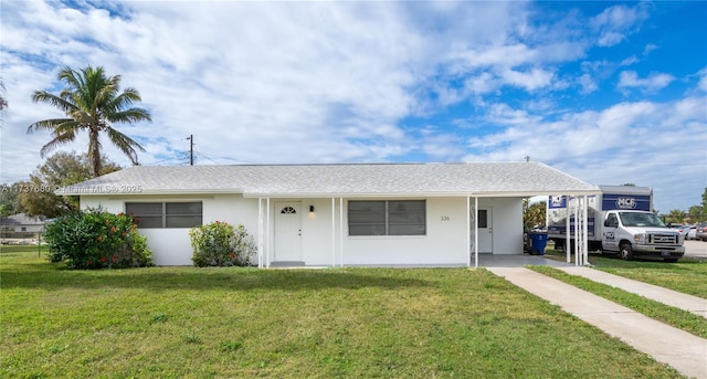 single story home featuring a front yard, a carport, and stucco siding