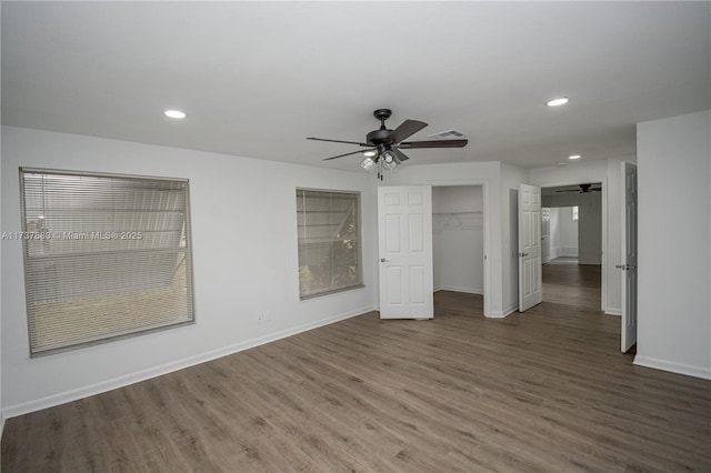 spare room with recessed lighting, wood finished floors, a ceiling fan, and baseboards