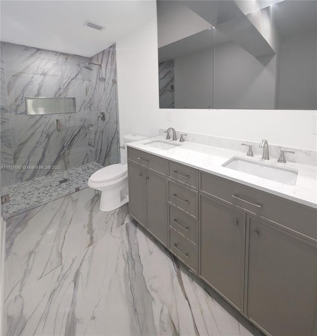 full bathroom with a marble finish shower, a sink, marble finish floor, and toilet