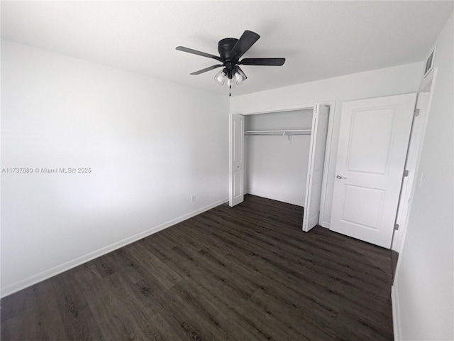 unfurnished bedroom featuring a closet, visible vents, dark wood-type flooring, ceiling fan, and baseboards