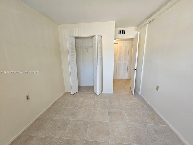 unfurnished bedroom with light tile patterned flooring and a closet