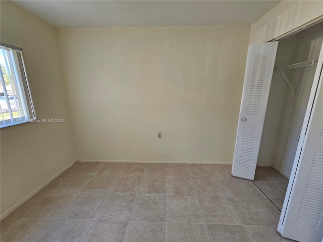 unfurnished bedroom featuring light tile patterned floors and a closet