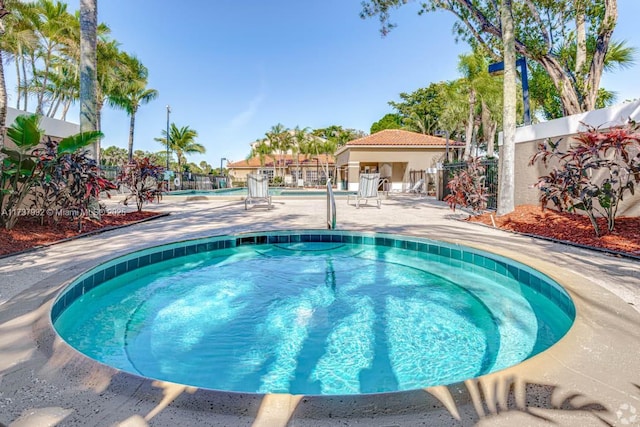 view of swimming pool with a hot tub