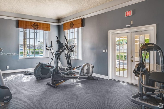 exercise area with french doors and a textured ceiling