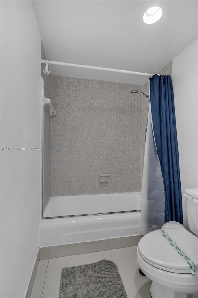 full bath featuring tile patterned flooring, shower / bath combo with shower curtain, and toilet
