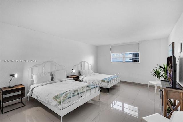 bedroom with tile patterned flooring and baseboards