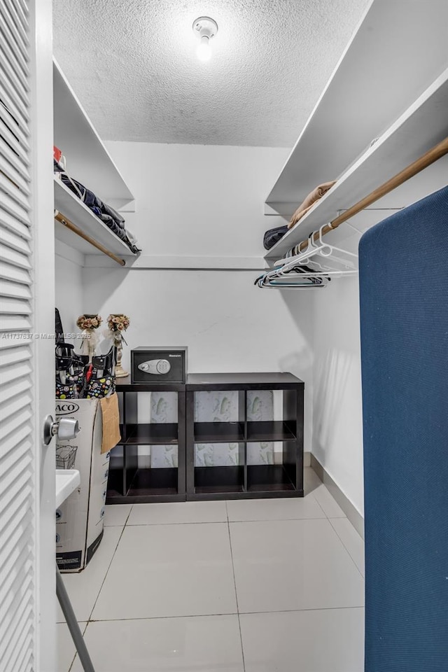 walk in closet with light tile patterned floors