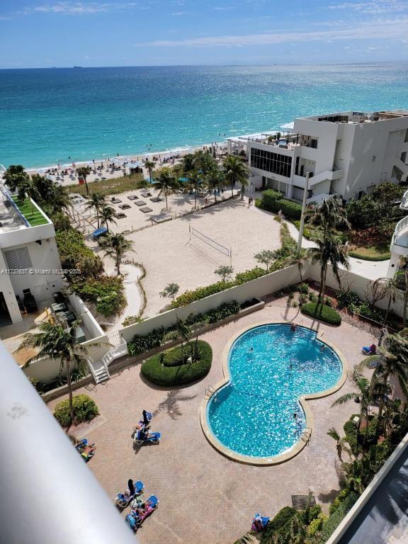 birds eye view of property featuring a beach view and a water view