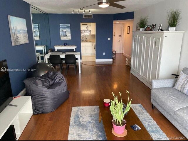 living room with dark hardwood / wood-style flooring, sink, and ceiling fan