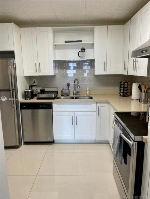 kitchen with white cabinetry, sink, backsplash, and stainless steel appliances