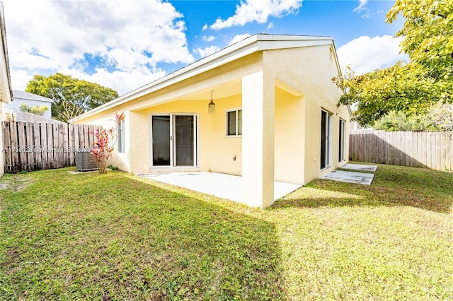 rear view of property featuring a lawn, central air condition unit, and a patio area