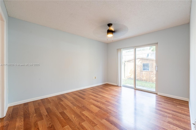 empty room with ceiling fan, light hardwood / wood-style floors, and a textured ceiling