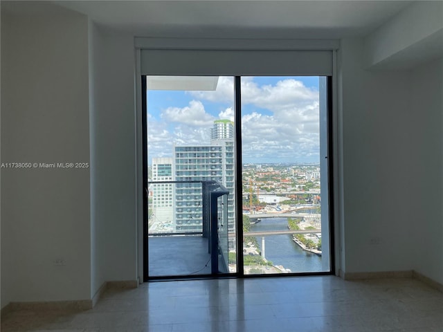 unfurnished room with a water view and expansive windows