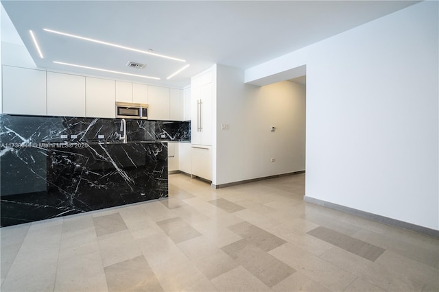 kitchen with white cabinetry and tasteful backsplash