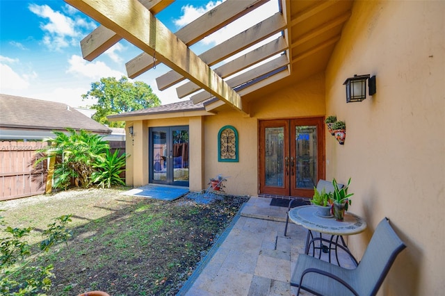 entrance to property with french doors, a pergola, and a patio