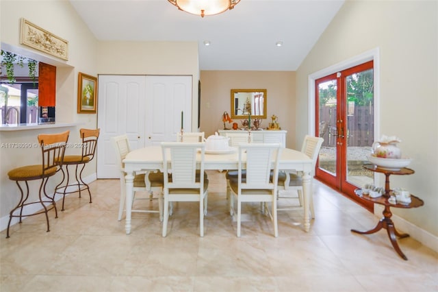 dining space featuring vaulted ceiling and french doors