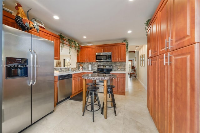 kitchen featuring a breakfast bar, sink, tasteful backsplash, a kitchen island, and stainless steel appliances