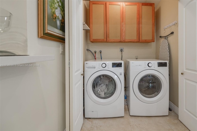 washroom featuring cabinets and washer and dryer