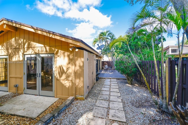 view of side of property with french doors and a wooden deck