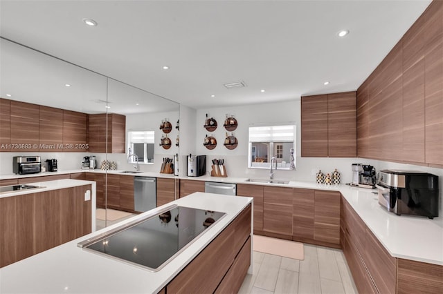 kitchen with stainless steel dishwasher, black electric stovetop, sink, and a kitchen island