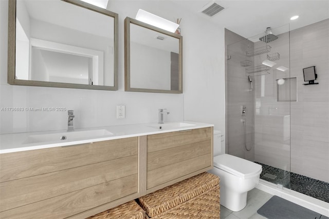 bathroom with vanity, toilet, and a tile shower