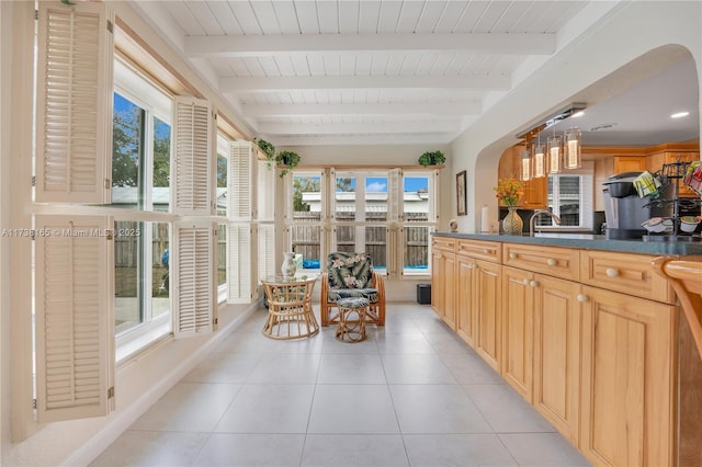 sunroom / solarium with a healthy amount of sunlight and beamed ceiling