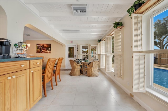 hall with light tile patterned floors, wooden ceiling, and beam ceiling