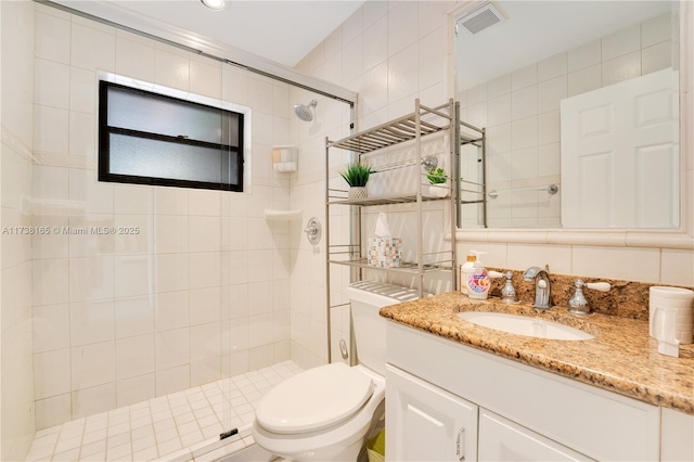 bathroom featuring walk in shower, toilet, tile walls, vanity, and backsplash