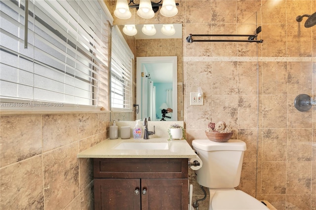 bathroom with tile walls, vanity, and toilet